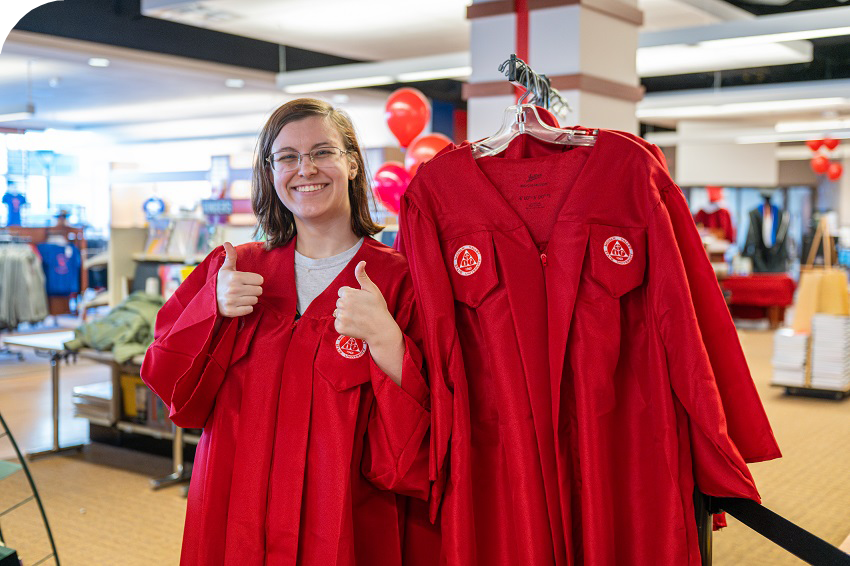 student trying on graduation gown at Grad Fair